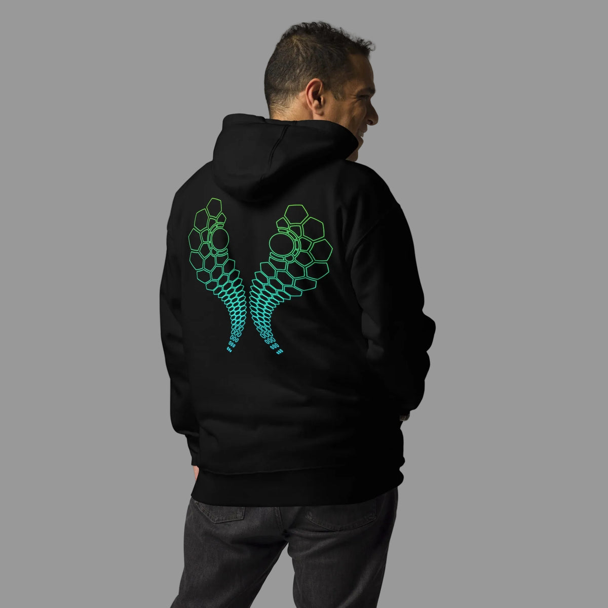 Hexa unisex cotton hoodie in Black, back view on a model: two mirrored arcs of hexagon cells, green to turquoise