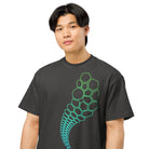 Hexa cotton box t-shirt in Vintage Black, detail on a model: large green cells and a circle shrinking into small hexagons
