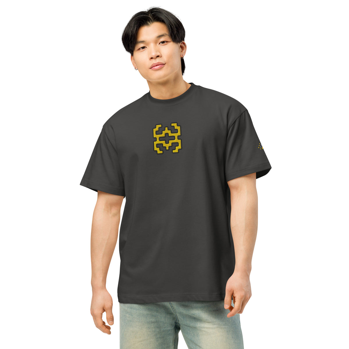 Invaders embroidered box tee in Vintage Black, front on a person: golden yellow stepped figure on the chest