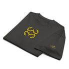 Invaders embroidered box tee in Vintage Black, folded, detail: golden yellow figure, yellow and grey dot mark on the sleeve