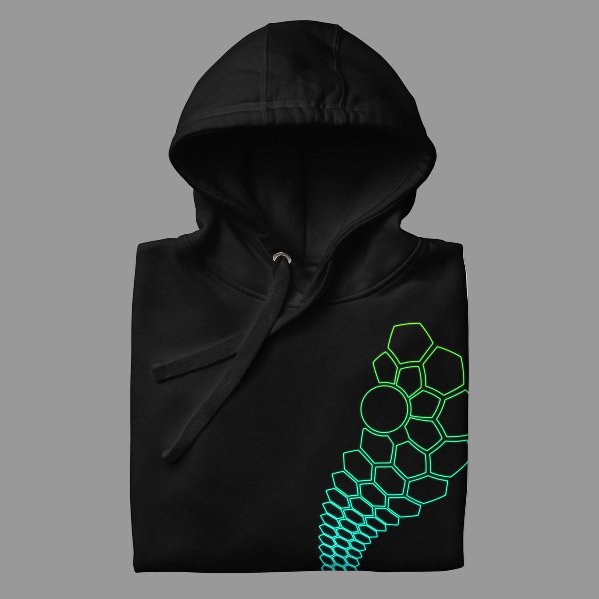 Hexa unisex cotton hoodie in Black, folded, detail: large green hexagon cells and a circle on the left chest